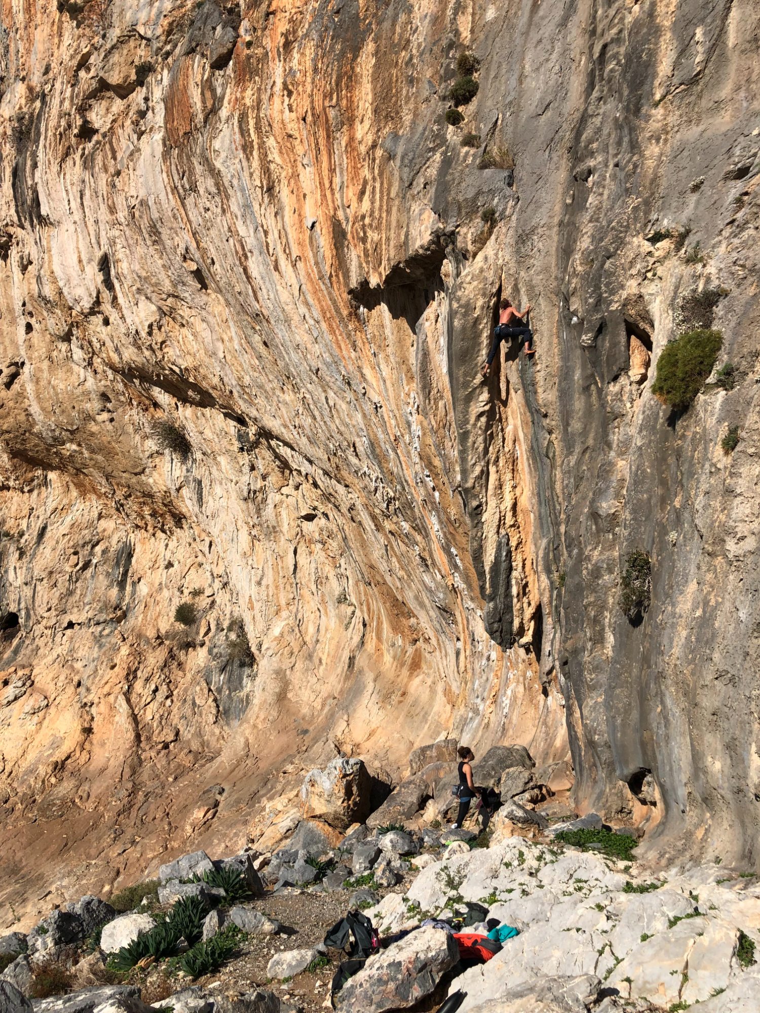 A climber high on a Kalymnos limestone wall above the sea